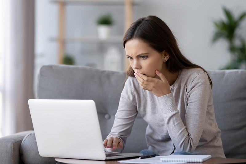 Shocked stressed woman reading bad online news looking at laptop